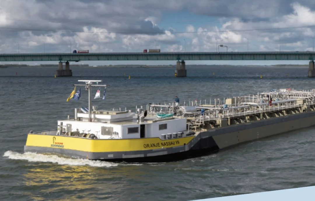 Oranje Nassau VII varend onder een brug